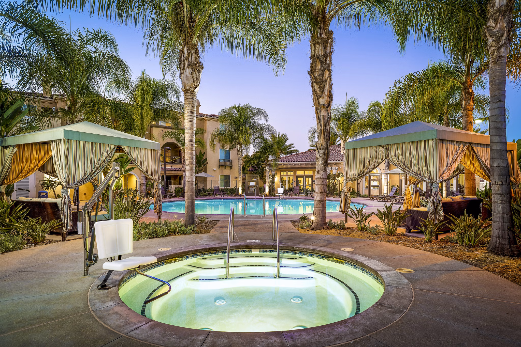 Luxurious pool at Tavera Apartments with sun loungers and lush landscaping