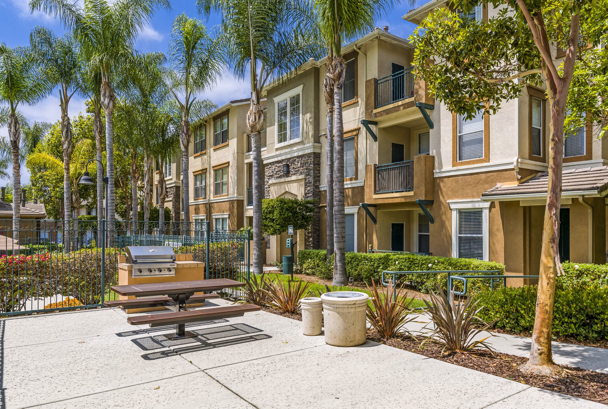 Outdoor grill area with modern seating at Terra Vista Apartments, ideal for social gatherings and alfresco dining