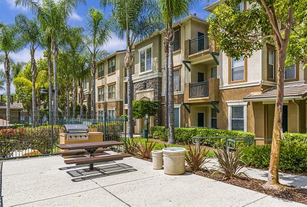 Outdoor grill area with modern seating at Terra Vista Apartments, ideal for social gatherings and alfresco dining