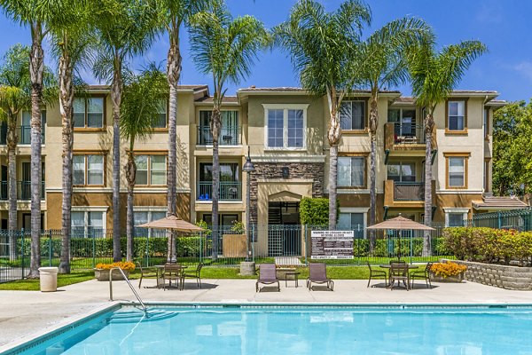 Plunge into relaxation at Terra Vista Apartments' luxury pool, featuring sleek sun loungers and lush landscaping for tranquil outdoor living