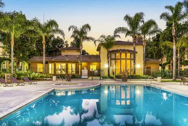 Relaxing blue swimming pool at Terra Vista Apartments with sun loungers in a scenic setting