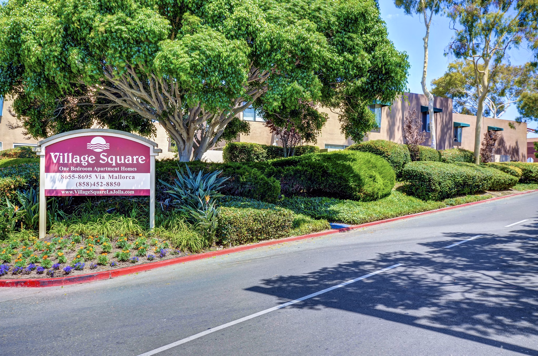 Village Square Apartments: Contemporary facade and landscaped grounds at luxury apartment community