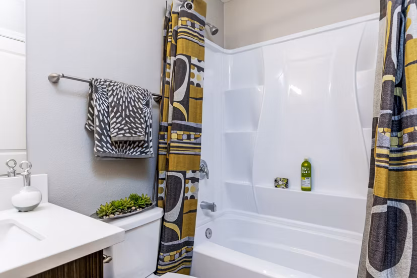 Bathroom with modern fixtures and large mirror at Village Square Apartments, a luxury community by Greystar