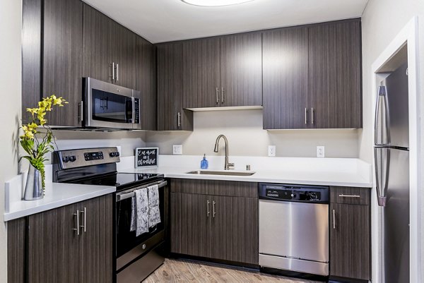 Modern kitchen with stainless steel appliances at Village Square Apartments for luxury living