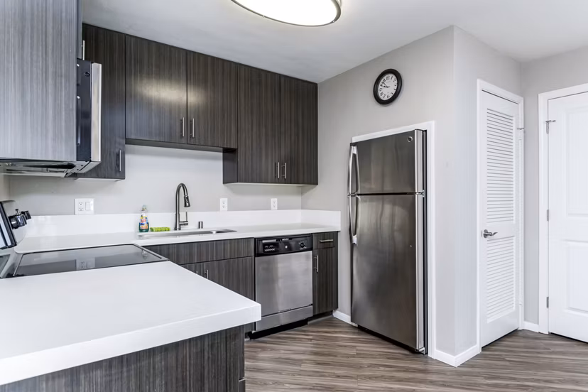 Modern kitchen with stainless steel appliances and granite countertops at Village Square Apartments