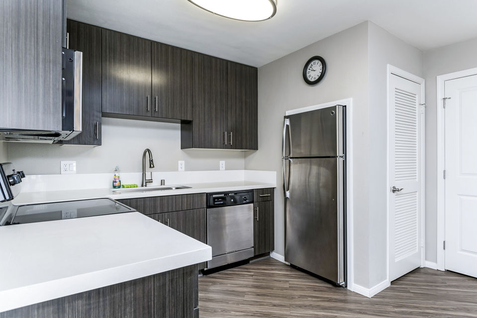 Modern kitchen with stainless steel appliances and granite countertops at Village Square Apartments