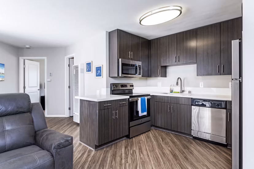 Village Square Apartments: Modern kitchen featuring sleek countertops and stainless steel appliances