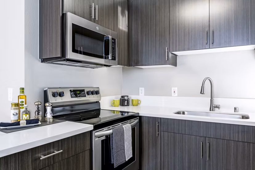 Modern kitchen with sleek countertops and stainless steel appliances at Village Square Apartments