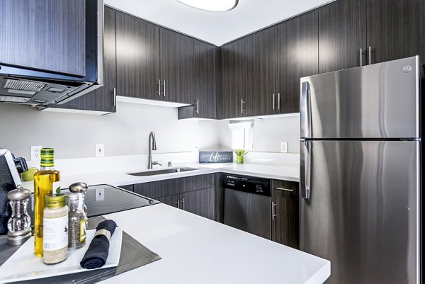 Modern kitchen featuring sleek cabinetry and stainless steel appliances at Village Square Apartments