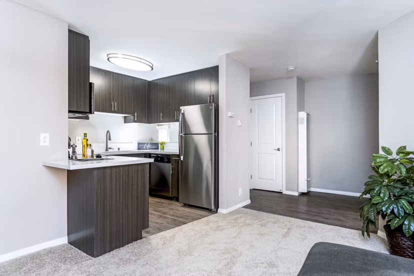 Spacious living room with modern furnishings in Village Square Apartments, luxury living offered by Greystar