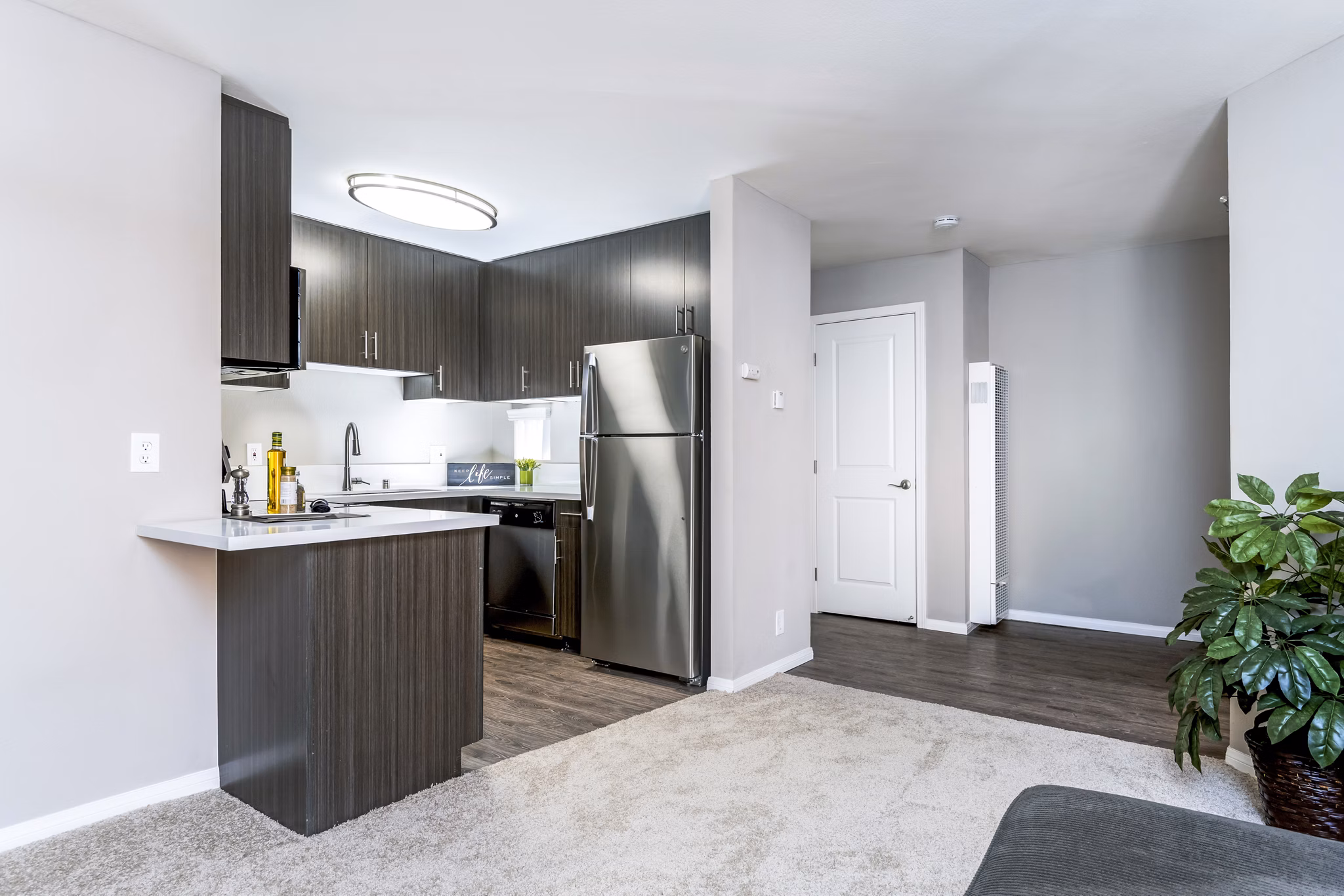 Spacious living room with modern furnishings in Village Square Apartments, luxury living offered by Greystar