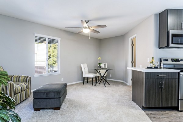 Spacious living room with modern decor in Village Square Apartments, featuring plush seating and abundant natural light