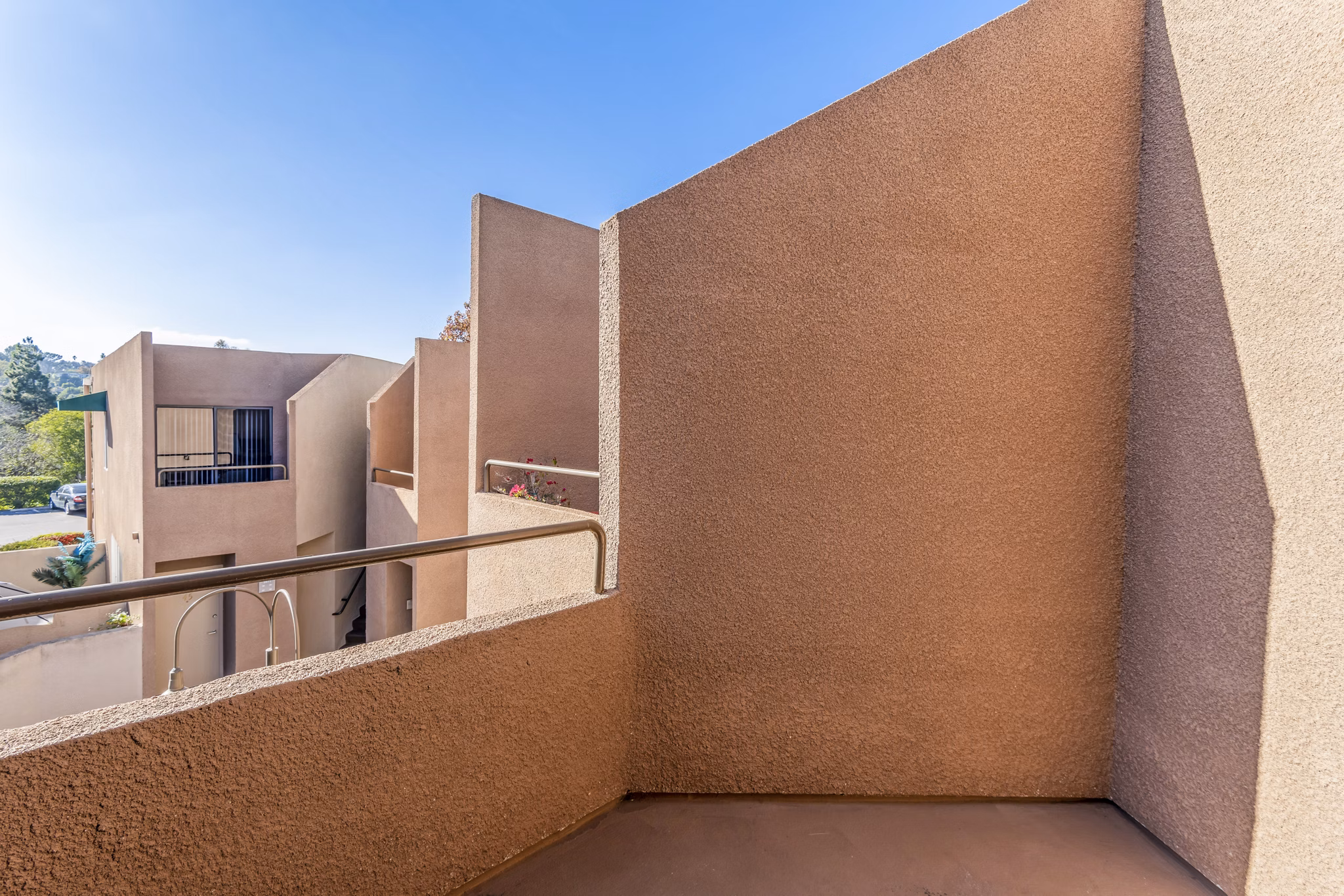 Private balcony with cozy seating at Village Square Apartments, perfect for relaxing and enjoying outdoor views