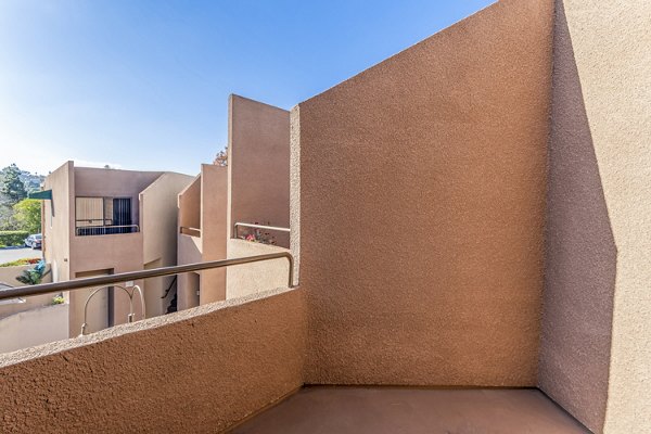 Private balcony with cozy seating at Village Square Apartments, perfect for relaxing and enjoying outdoor views