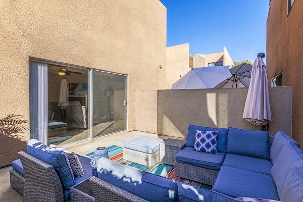 Cozy patio with outdoor seating at Village Square Apartments, perfect for relaxing and enjoying views of the surroundings