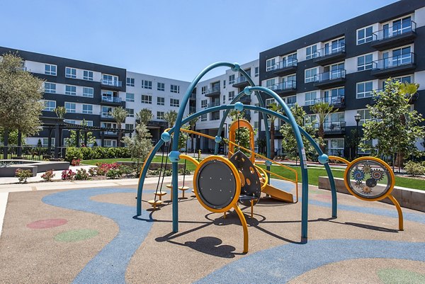 Modern playground at Vora Mission Valley West Apartments with colorful equipment for children to play and explore