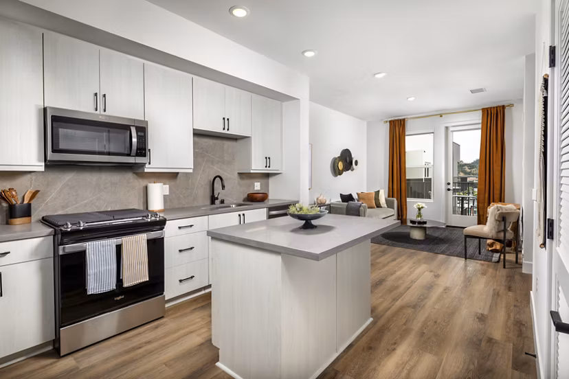Modern kitchen with stainless steel appliances and granite countertops at Vora Mission Valley East Apartments in San Diego