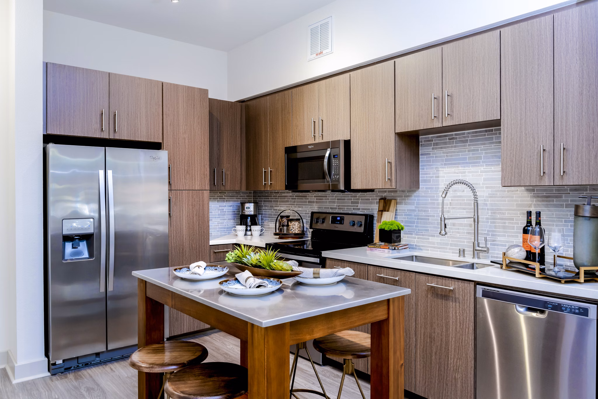 Modern kitchen with stainless steel appliances and granite countertops at Vora Mission Valley East Apartments in San Diego
