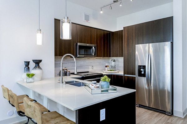 Modern kitchen with stainless steel appliances at Vora Mission Valley East Apartments, highlighting luxury design and functionality