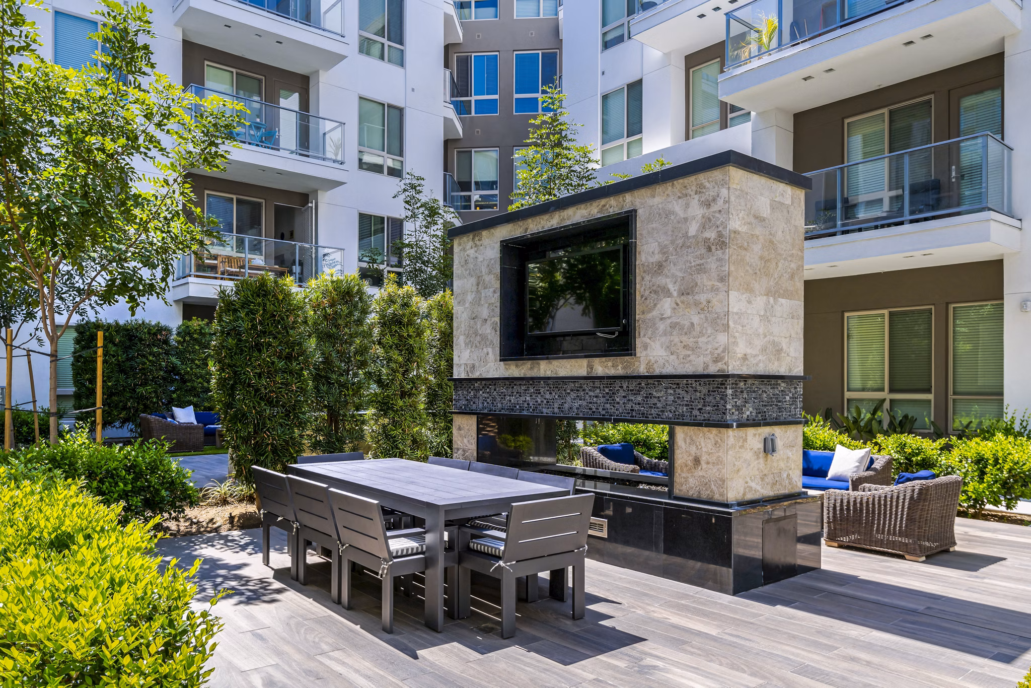 Vora Mission Valley East Apartments: Outdoor patio featuring modern seating and lush landscaping in a vibrant San Diego community