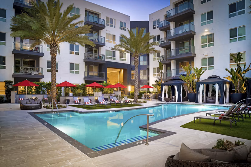 Stylish pool at Vora Mission Valley East Apartments with lounge chairs and lush landscaping, ideal for relaxation in San Diego