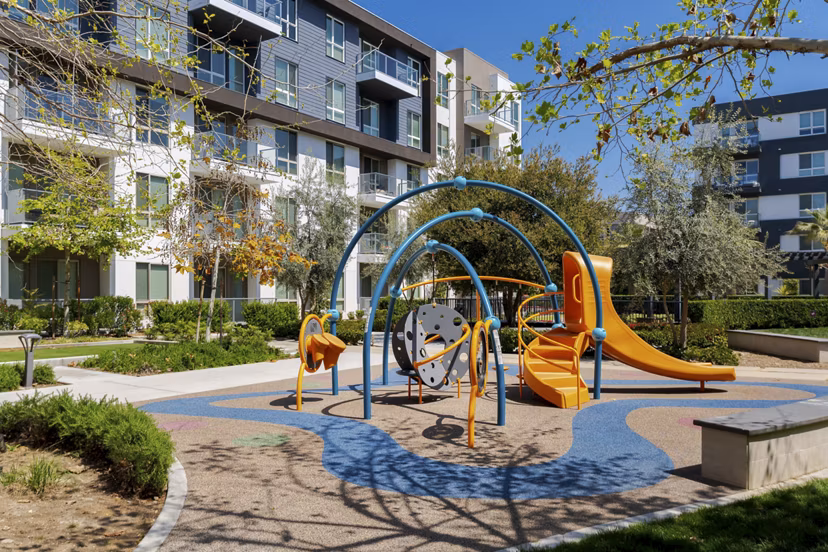 Playground with slides and swings at Vora Mission Valley East Apartments, a family-friendly Greystar community in sunny San Diego