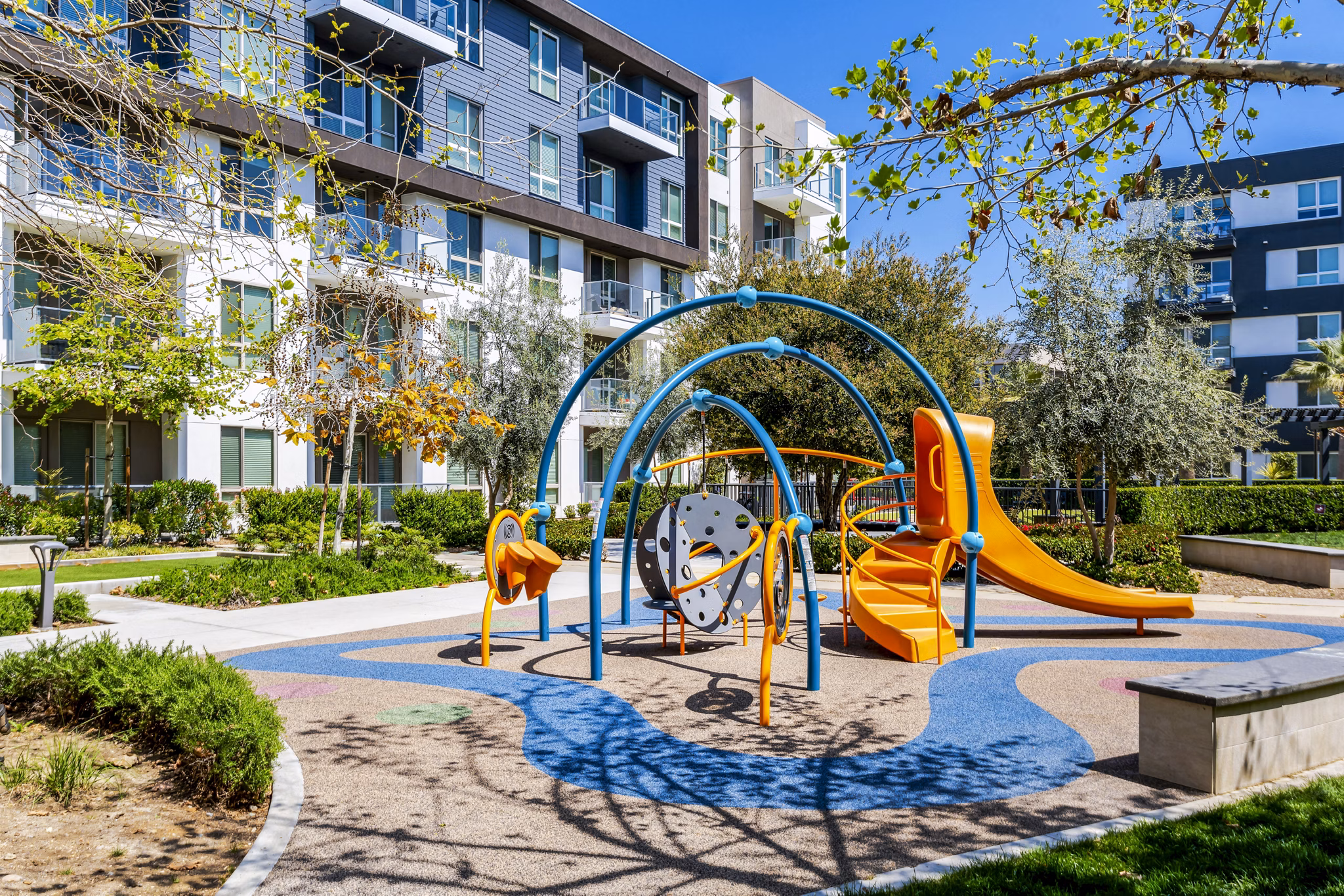 Playground with slides and swings at Vora Mission Valley East Apartments, a family-friendly Greystar community in sunny San Diego