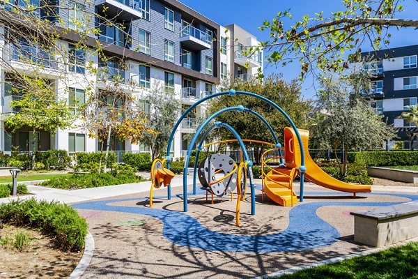 Playground with slides and swings at Vora Mission Valley East Apartments, a family-friendly Greystar community in sunny San Diego