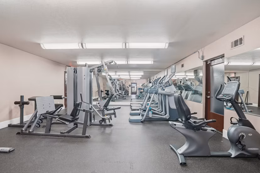 Yoga studio with wood flooring and mirrored walls at Shadowridge Woodbend Apartments