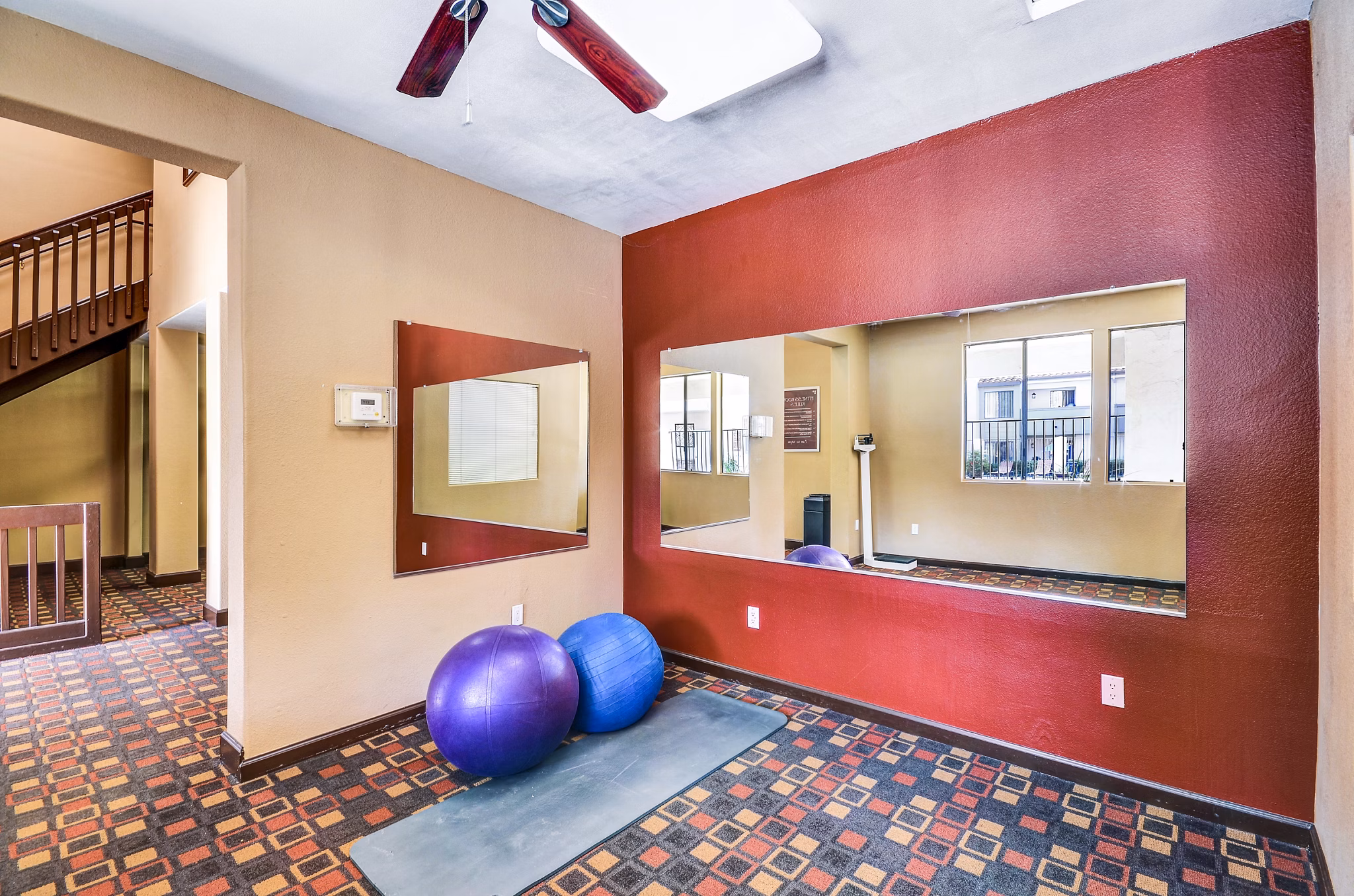 Yoga studio with wood flooring and mirrored walls at Shadowridge Woodbend Apartments