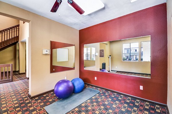 Yoga studio with wood flooring and mirrored walls at Shadowridge Woodbend Apartments