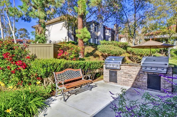 Outdoor grill area with modern seating at Shadowridge Woodbend Apartments, perfect for social gatherings in a luxury apartment community