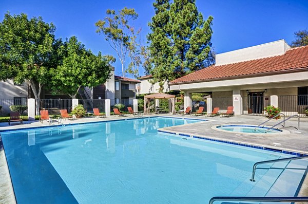 Resort-style pool at Shadowridge Woodbend Apartments with lounge chairs and lush landscaping