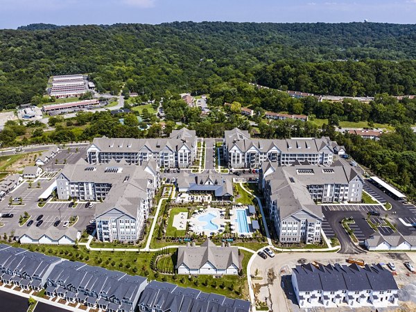 Modern swimming pool area with red Adirondack chairs and luxury apartments in the background