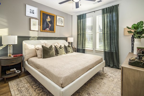 Luxurious bedroom with king-sized bed at NOVEL Harpeth Heights by Crescent Communities Apartments, ideal for comfortable city living
