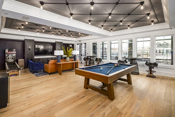 Clubhouse game room with billiards table and lounge seating at NOVEL Harpeth Heights by Crescent Communities Apartments
