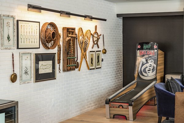 Clubhouse game room with billiards and cozy seating at NOVEL Harpeth Heights by Crescent Communities Apartments