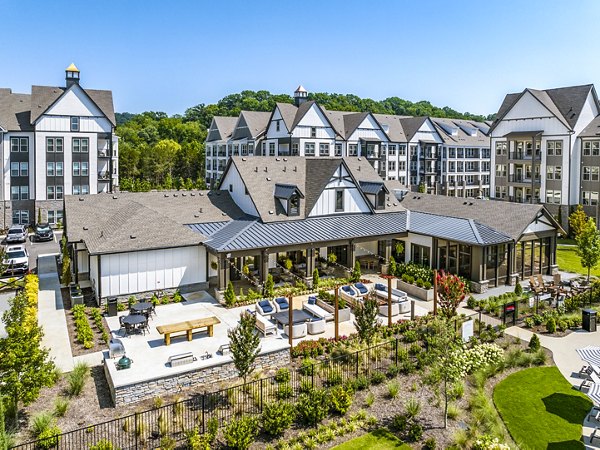 Luxury apartment complex with landscaped gardens and outdoor seating areas in a serene residential setting