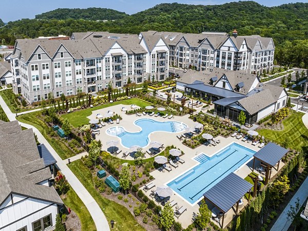 Outdoor swimming pool area with lounge chairs and luxury apartments in the background