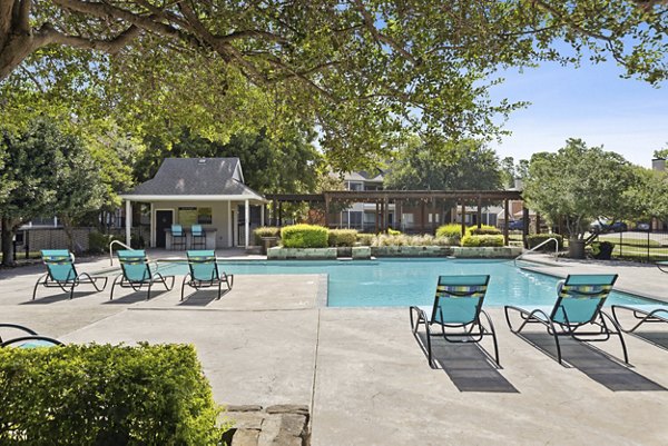 Resort-style pool with lounge chairs at Ashford Apartments, offering luxury outdoor relaxation