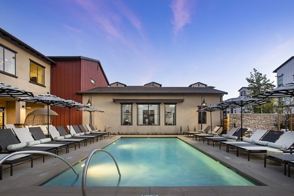 Resort-style pool with loungers at Kendry Apartments providing a luxurious outdoor retreat