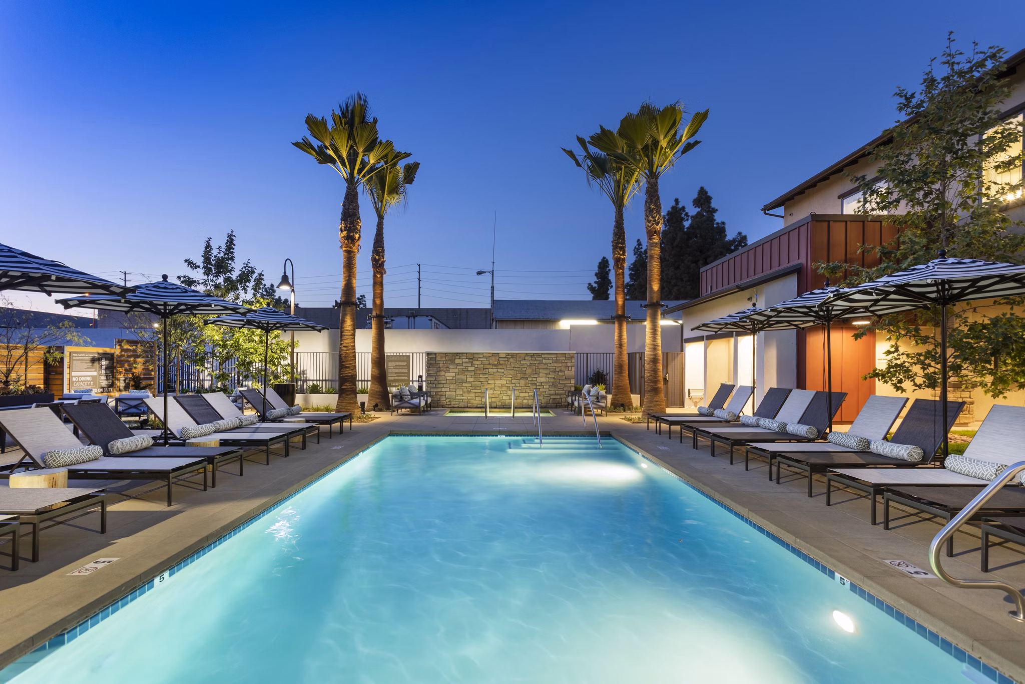 Kendry Apartments: Resort-style pool with cabanas and loungers, perfect for relaxation and leisure activities in luxury living environment
