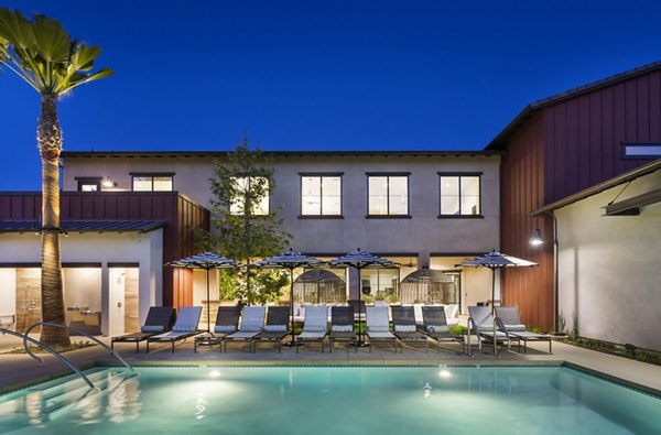 Resort-style pool with lounge chairs at Kendry Apartments, offering luxury living and relaxation for residents