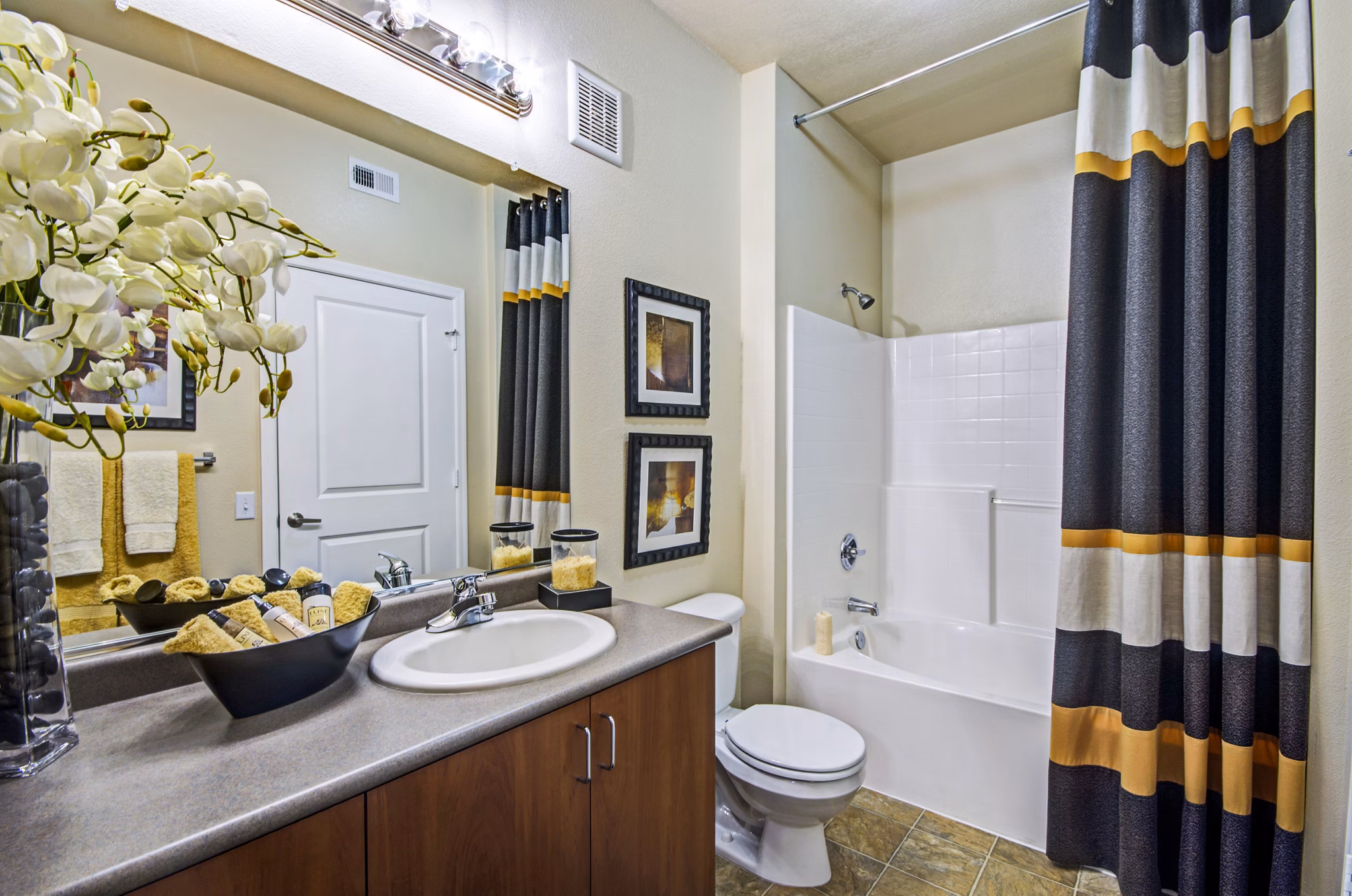 Modern bathroom with marble countertops and glass-enclosed shower at Ridgestone Apartments