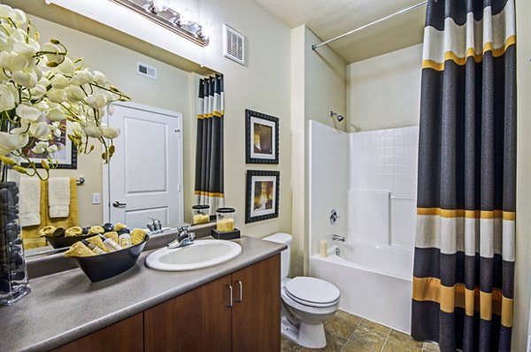 Modern bathroom with marble countertops and glass-enclosed shower at Ridgestone Apartments