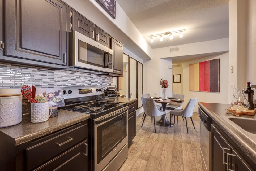 Contemporary kitchen featuring stainless steel appliances and granite countertops at Solana Ridge Apartments