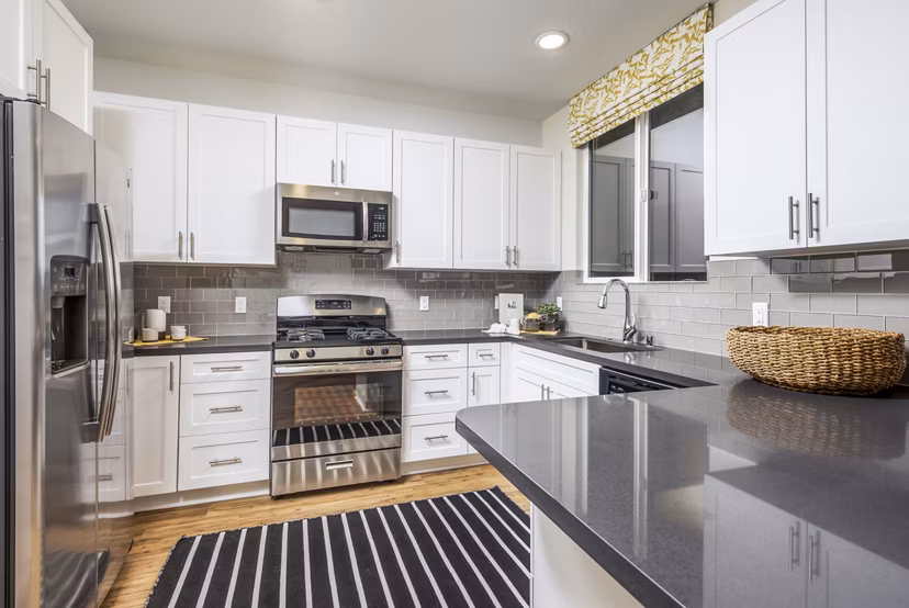 Kitchen featuring modern appliances and sleek countertops at Sorano Apartments
