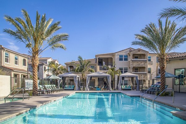 Resort-style swimming pool with sun loungers at Sorano Apartments luxury community