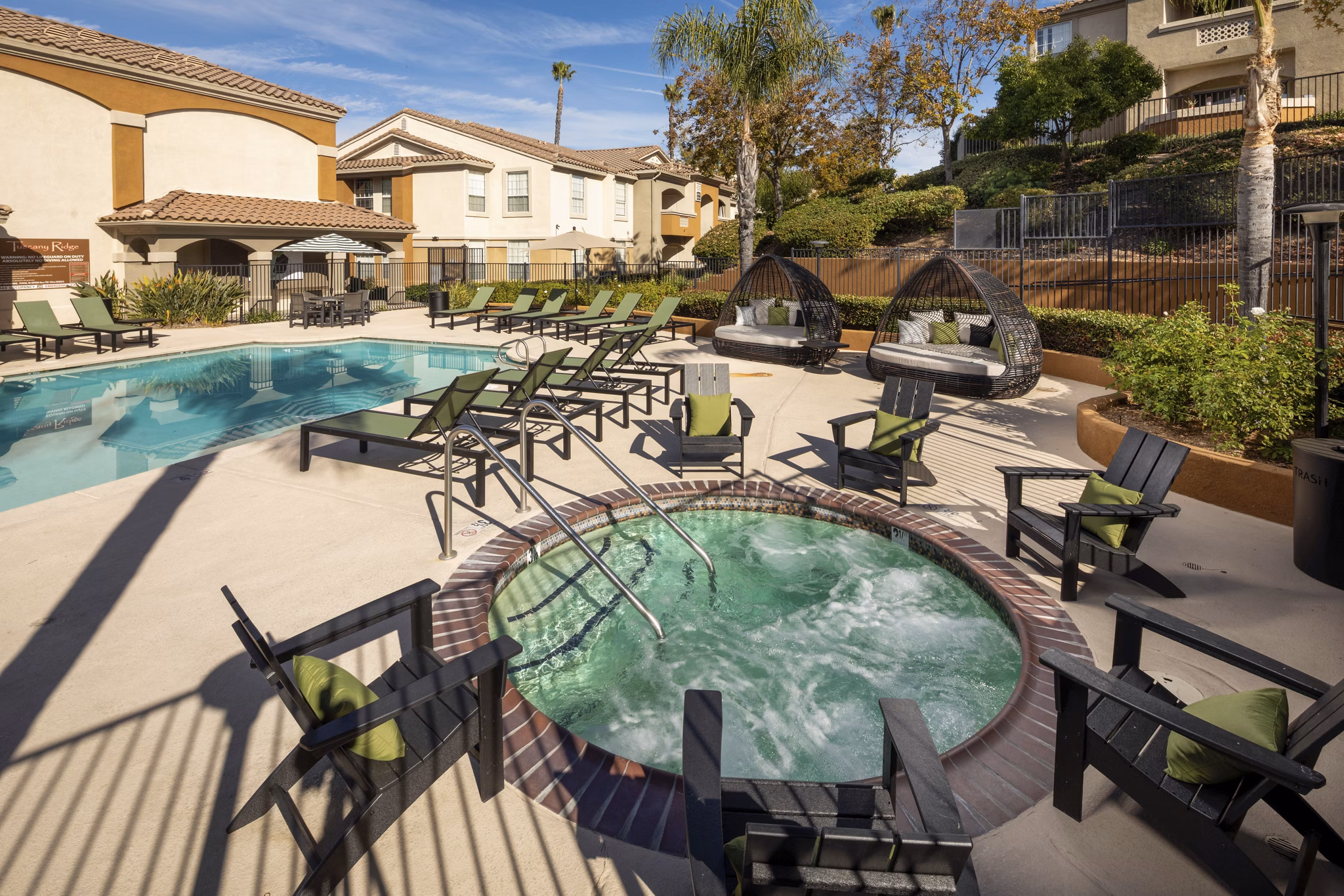 Resort-inspired pool with sun loungers at Tuscany Ridge Apartments, offering luxury living and leisure in a serene setting