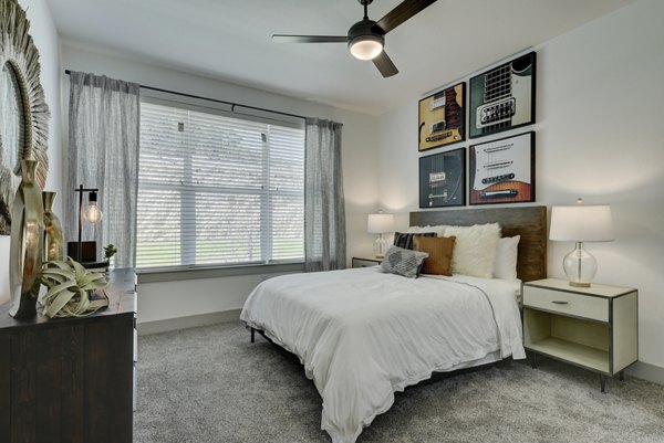 Cozy bedroom with modern decor in Arbolada Apartments, featuring stylish furnishings and ample natural light for luxury living